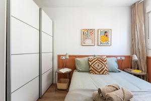a bedroom with a bed and a white wall at Sunset House in Málaga