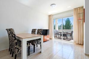 a dining room with a table and chairs and a balcony at La Moreneta in Miami Platja