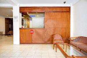 バンダ・アチェにあるCollection O Peunayong Near Masjid Raya Baiturrahman Formerly Siwah Hotelのロビーにある大きな木製のドアと2脚の椅子