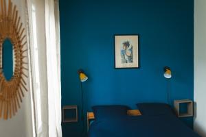 Habitación azul con sofá y pared azul en Le petit baigneur, 300m de la mer et centre ville, en Étretat