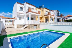 a villa with a swimming pool in front of a house at La Moreneta in Miami Platja