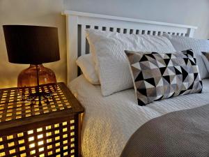 a bedroom with a bed with a table with a lamp at The Lodge in Wadhurst +2 photos