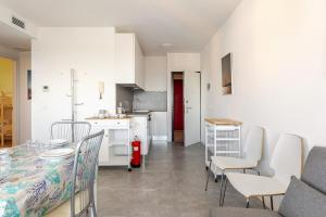 a kitchen and dining room with a table and chairs at La Terrazza sul Mare with parking in Lignano Sabbiadoro