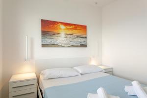 a bedroom with a bed and a painting on the wall at La Terrazza sul Mare with parking in Lignano Sabbiadoro