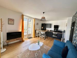 a living room with a blue couch and a kitchen at White House - THE SUNNY avec TERRASSE et PARKING privé - 20 min CENTRE in Amiens