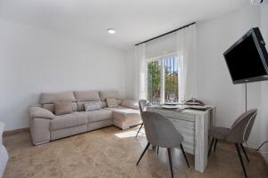 salon z kanapą, stołem i krzesłami w obiekcie Apartamento Los Jardines w mieście El Puerto de Santa María