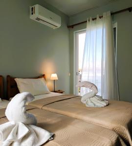 a bedroom with two swans made out of towels on a bed at Siora Angie in Agios Gordios