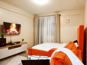 Una habitación de hotel con una cama y un televisor. en R&R NAI-POSHA Studios, en Naivasha