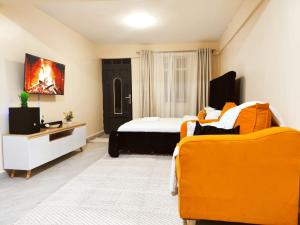 1 dormitorio con cama y sofá amarillo en R&R NAI-POSHA Studios, en Naivasha