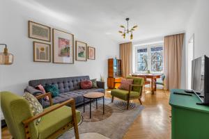 a living room with a couch and chairs and a table at Wola Ratusz Serene Apartment by BookingHost in Warsaw
