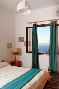 a bedroom with a bed and a large window at Villa Kapare in Kókkinon Khoríon