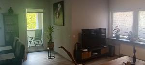 a living room with a flat screen tv and a table at Casa Pura Vida in Rees
