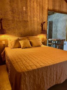 a bedroom with a large bed with an orange comforter at Village Choça in Acaraú