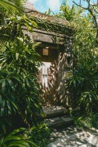 a small entrance to a building with plants at Vije Boutique Resort & Spa in Ubud