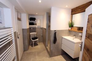 a small kitchen with a sink and a chair at Ferienhaus Charlotte in Goslar +10 photos