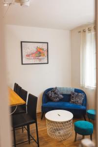 Una sala de estar con un sofá azul y una mesa. en Le petit baigneur, 300m de la mer et centre ville, en Étretat