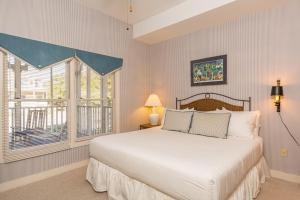 Un dormitorio con una cama grande y una ventana. en Grand Pavilion 83 by Wild Dunes, en Isle of Palms