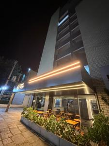 a building with tables and chairs in front of it at night at Hotel do Vale in Campina Grande
