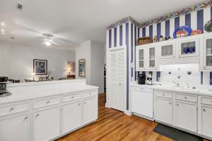 Una gran cocina blanca con armarios blancos y una encimera. en Grand Pavilion 83 by Wild Dunes, en Isle of Palms