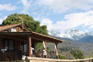 a log cabin with mountains in the background at La CABAÑA in Candeleda