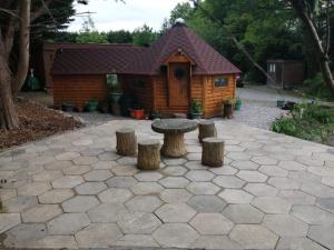 a log cabin with a table and stools in front at The Cabin & hot tub at Ashleigh House in Holland Arms Station