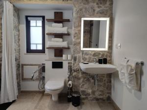 a bathroom with a sink and a toilet and a mirror at Casa do Cruzeiro in Ourém