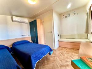 a room with two beds and a tub in it at Camping Village Tuscia Tirrenica in Tarquinia