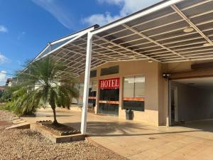 a hotel with a palm tree in front of a building at Big Hotel in Imperatriz