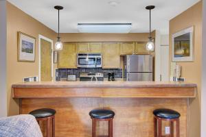 a kitchen with a bar with two stools at Lagoon Villas 13 by Wild Dunes, with Amenities in Isle of Palms