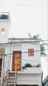 a white house with two windows and a staircase at Blue Beach Ahangama in Ahangama