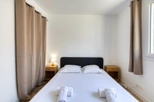 a bedroom with a bed with two towels on it at Maison Epica - Welkeys in Saint-Pierre-dʼOléron +4 photos