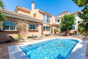 una casa con piscina delante de una casa en Villa Aurora, en Santa Fe de los Boliches