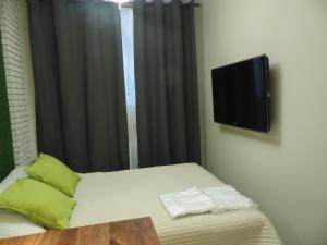 a bedroom with a bed with a tv on the wall at Berloga on Cheluskintsev in Yekaterinburg