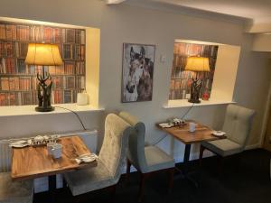 a restaurant with two tables and chairs and books at OYO Cocketts Hotel in Hawes