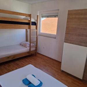 une chambre avec deux lits superposés et une fenêtre dans l'établissement Apartments Oliva - Maslina, à Bilice