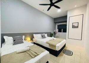 une chambre avec deux lits et un ventilateur de plafond dans l'établissement Tambun Guesthouse 14pax nearby Sunway by IWH Suites, à Ipoh