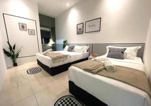une chambre avec deux lits dans une pièce dans l'établissement Tambun Guesthouse 14pax nearby Sunway by IWH Suites, à Ipoh