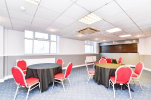 a conference room with two tables and red chairs at Aston Court Derby City Centre by Belvilla in Derby +87 photos