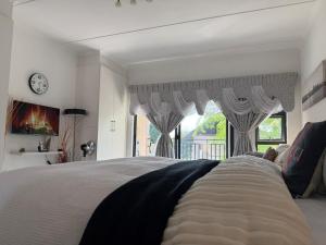 a bedroom with a large bed and a window at Dainfern Cozy Condo in Midrand