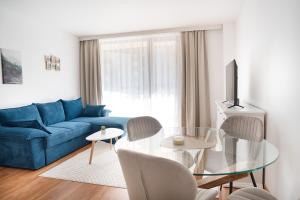 Una sala de estar con un sofá azul y una mesa de cristal. en Pirin Sense Amazing Studio - Spa - FREE Parking, en Bansko