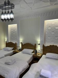 Un dormitorio con dos camas y una lámpara de araña. en Amina Hotel boutique, en Bukhara 54 fotos más