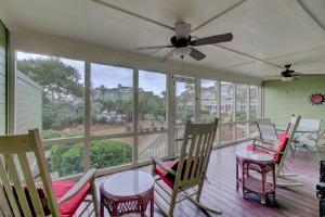 a porch with chairs and tables and a ceiling fan at Mariners Walk 4C by Wild Dunes, Ocean View Condo in Isle of Palms