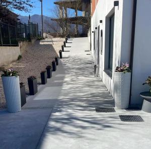a sidewalk with potted plants on the side of a building at Amataville in Lioni