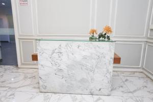 a marble counter with two flowers on top of it at Collection O metroploitian park Serviced Apartmen in Bekasi