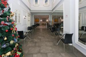 a christmas tree in a room with chairs at Collection O metroploitian park Serviced Apartmen in Bekasi