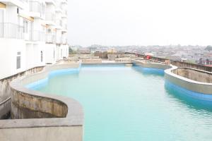 a river with blue water and buildings in the background at Collection O metroploitian park Serviced Apartmen in Bekasi