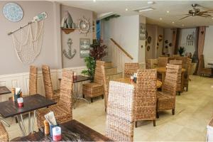 a restaurant with tables and chairs in a room at The Belgrave Hotel Tenby in Tenby