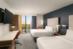 a hotel room with two beds and a desk at Courtyard by Marriott Boynton Beach in Boynton Beach +13 photos