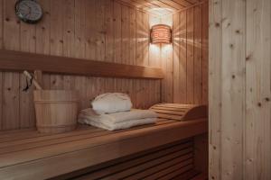 eine Sauna mit Handtüchern auf einem Regal und einer Uhr in der Unterkunft Alpzitt-Chalets in Burgberg + 37 Fotos