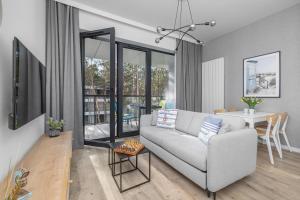 a living room with a couch and a table at Apartament Relax Rogowo Balkon & Parking by Noclegi Renters in Rogowo